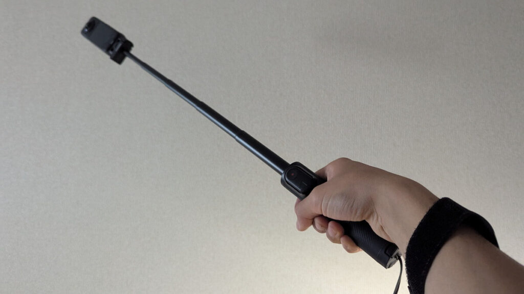 Insta360 X5を折りたたみ自撮り棒に付けて伸ばしている様子
